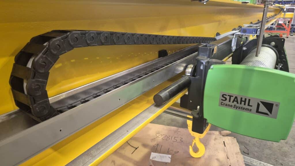 Detail van de kabelrups op een kraanligger, met de STAHL-takel ernaast in de werkplaats van CraneSolutions